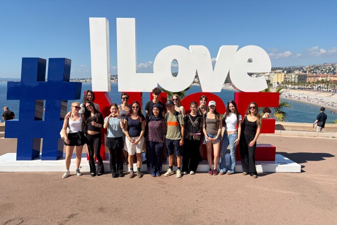 #IloveNice: Gruppe junger Leute vor der bekannten Schriftinstallation mit Blick auf die Bucht der Engel.
